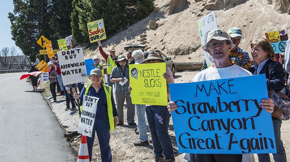 Protestors hold signs opposing Nestlé